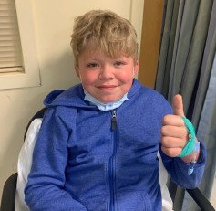 boy at doctors smiling with thumbs up