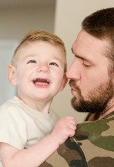 father holding smiling young boy