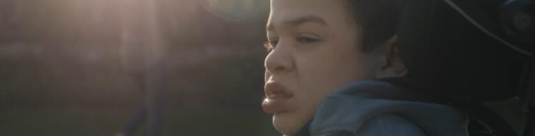 boy in wheelchair with sun beams