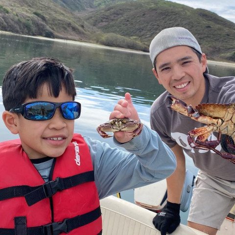 Noah and his dad holding up crabs