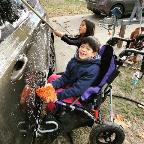 Noah cleaning a car with his sister