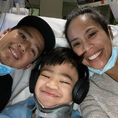 Noah smiling with his mom and dad while in the hospital